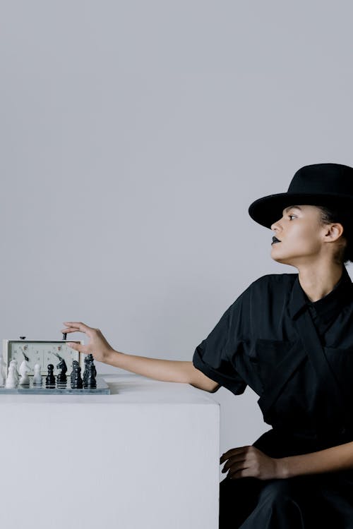 Free Woman in a Black Hat Pressing Chess Clock Stock Photo