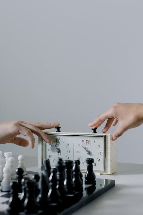 People Pressing Chess Clock Buttons