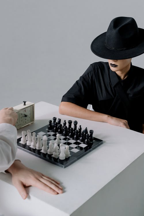 Woman in Black Clothing Playing Chess