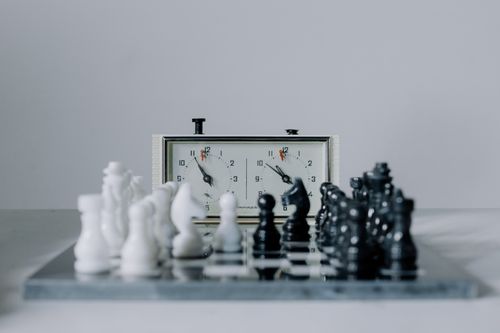 Free Close-up view of a chess match featuring black and white pieces and a chess clock. Stock Photo