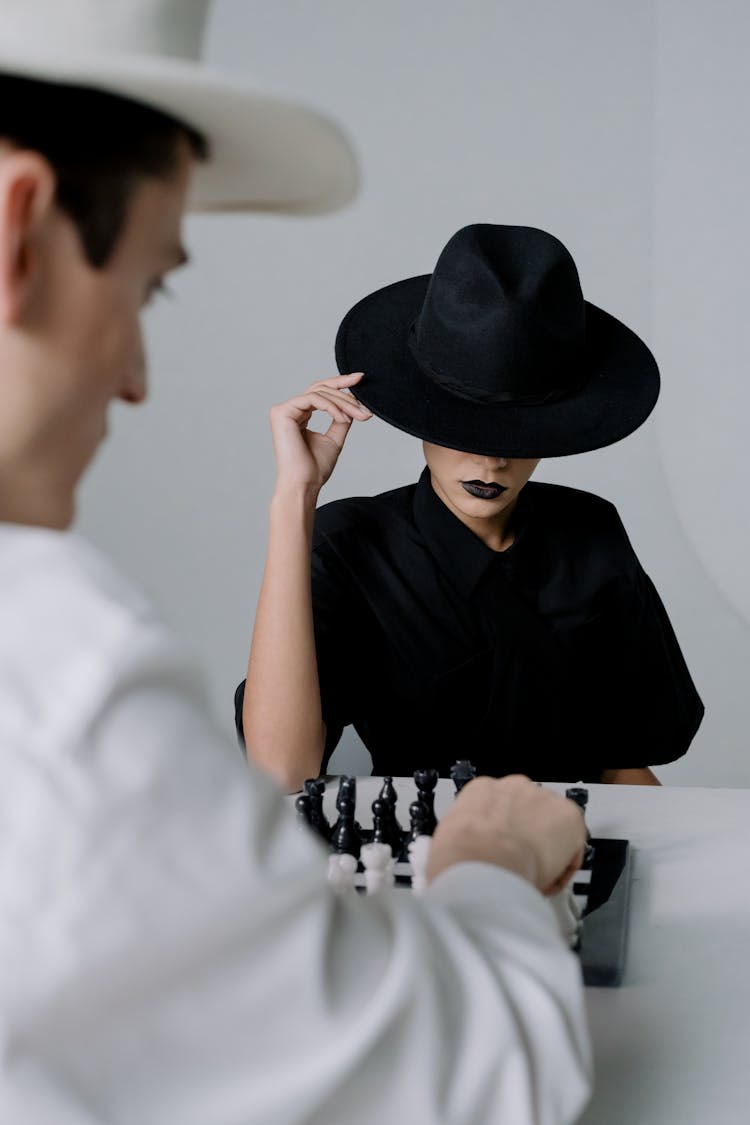 People Wearing Hat Playing Chess