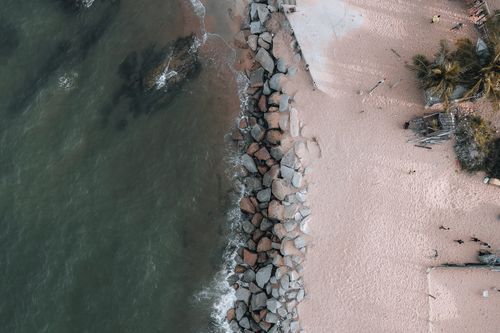 Free Aerial view of a sandy beach with rocks and calm waters in Chukai, Terengganu, Malaysia. Stock Photo