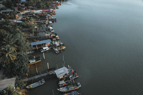 Free Aerial perspective of docked boats along the river in Chukai, Terengganu, Malaysia, showcasing serene waterways and vibrant ports. Stock Photo