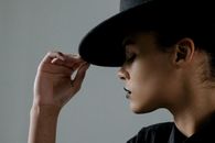 Close-Up Shot of a Woman Holding Her Black Hat