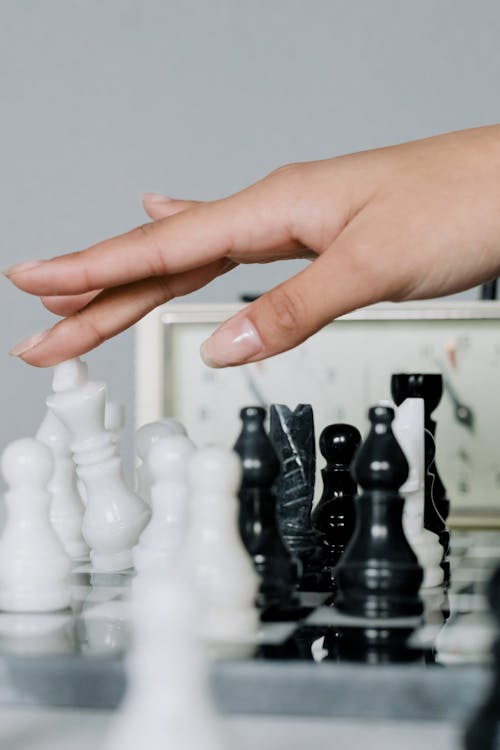 Person Holding White Chess Piece