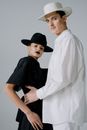 Man in White Long Sleeve Shirt Hugging Woman in Black Dress