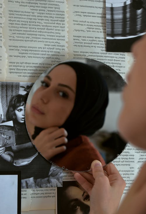 Reflection of a Woman on a Round Mirror Wearing Black Hijab