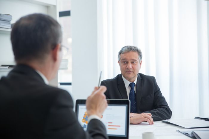 Zwei Personen im Gespräch am Besprechungstisch mit Auswertung auf dem Laptop