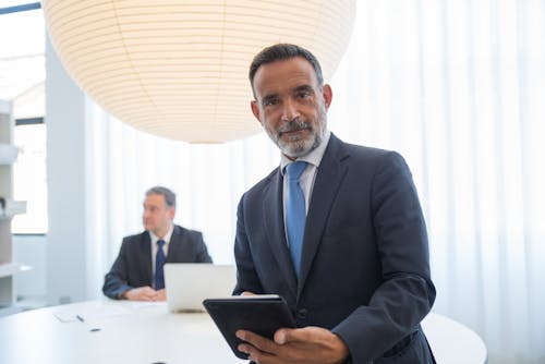 Businessman in a Suit Holding a Tablet
