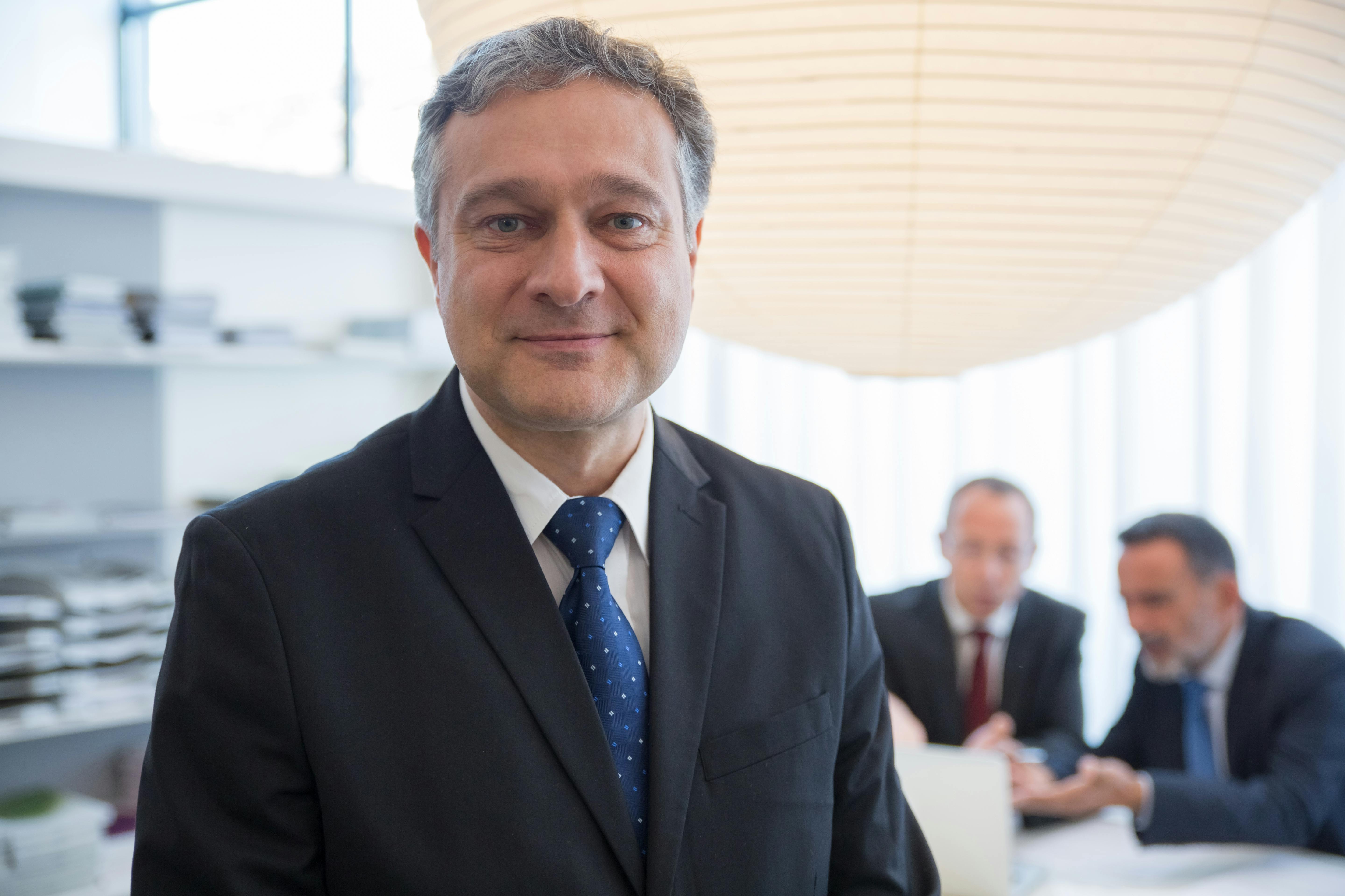 Businessman in a suit with colleagues in a modern office in Portugal.