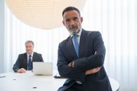 Man in Black Suit Sitting on Chair
