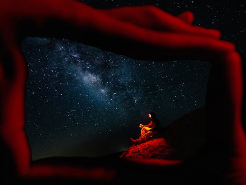 Free A Person Sitting under a Starry Sky Stock Photo