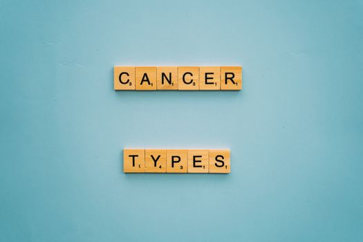 Wooden letter tiles spelling 'Cancer Types' on a blue background.