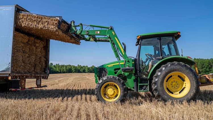 A Tractor Loading A Hay On The Truck