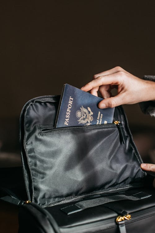 Free Person Putting a Passport on Bag Stock Photo