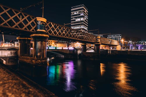 무료 밤 시간 동안 갈색 콘크리트 다리와 고층 건물의 건축 사진 스톡 사진