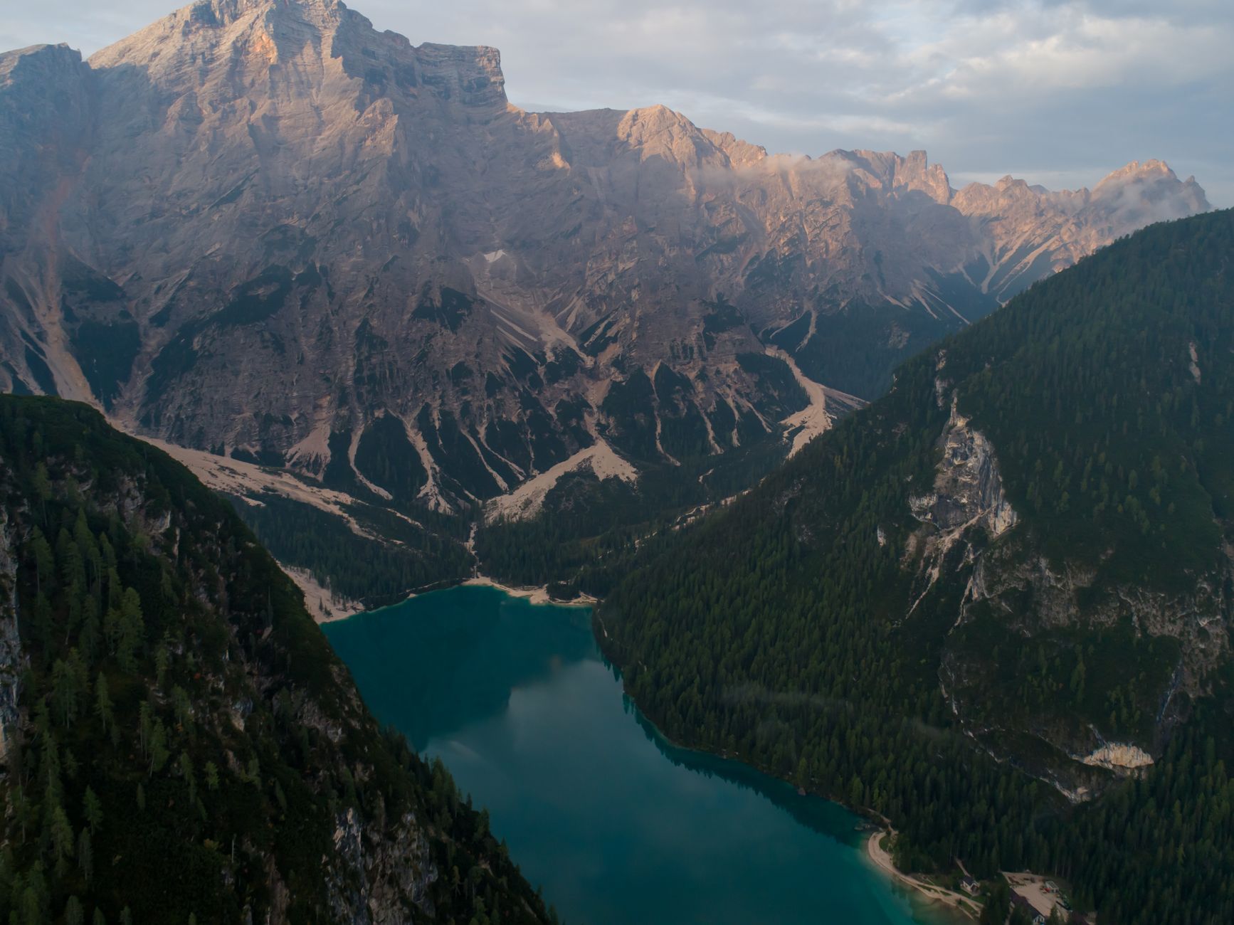 cinematic emerald alpine lake with towering rocky mountains at sunrise