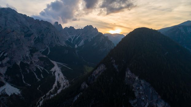 A breathtaking aerial view of a mountain range with a sunset backdrop, creating a dramatic and scenic landscape.