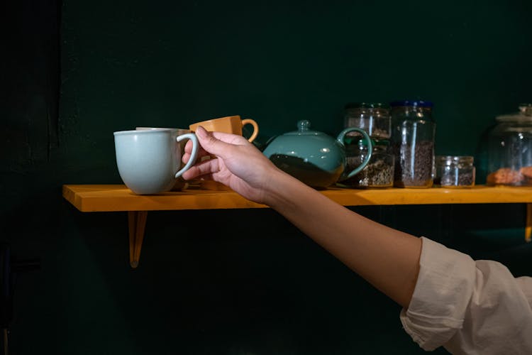 Photo Of A Hand Reaching For A Cup