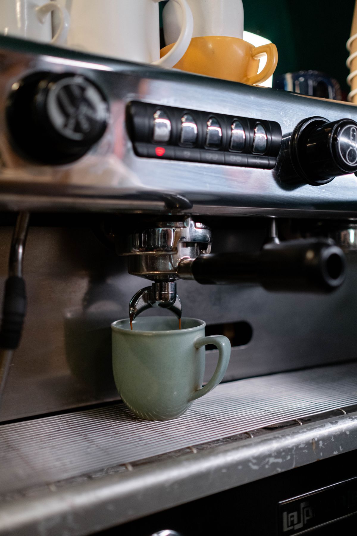 Close-up of an espresso machine brewing into a cup, for illustration