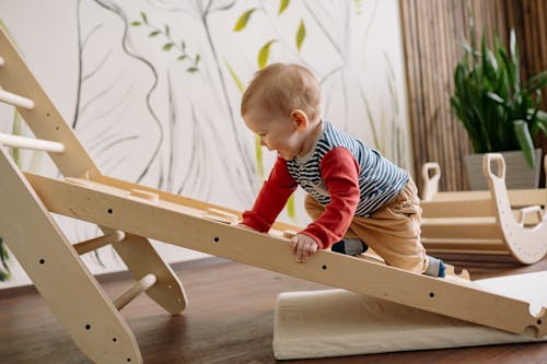 Happy Toddler Climbing Up a Wooden Ladder 