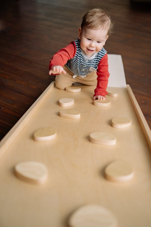 Baby Climbing Up a Little Wooden Climbing Wall 