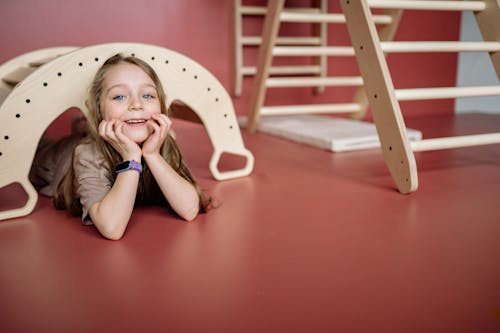 Happy Little Girl Under a Wooden Toy Bridge 