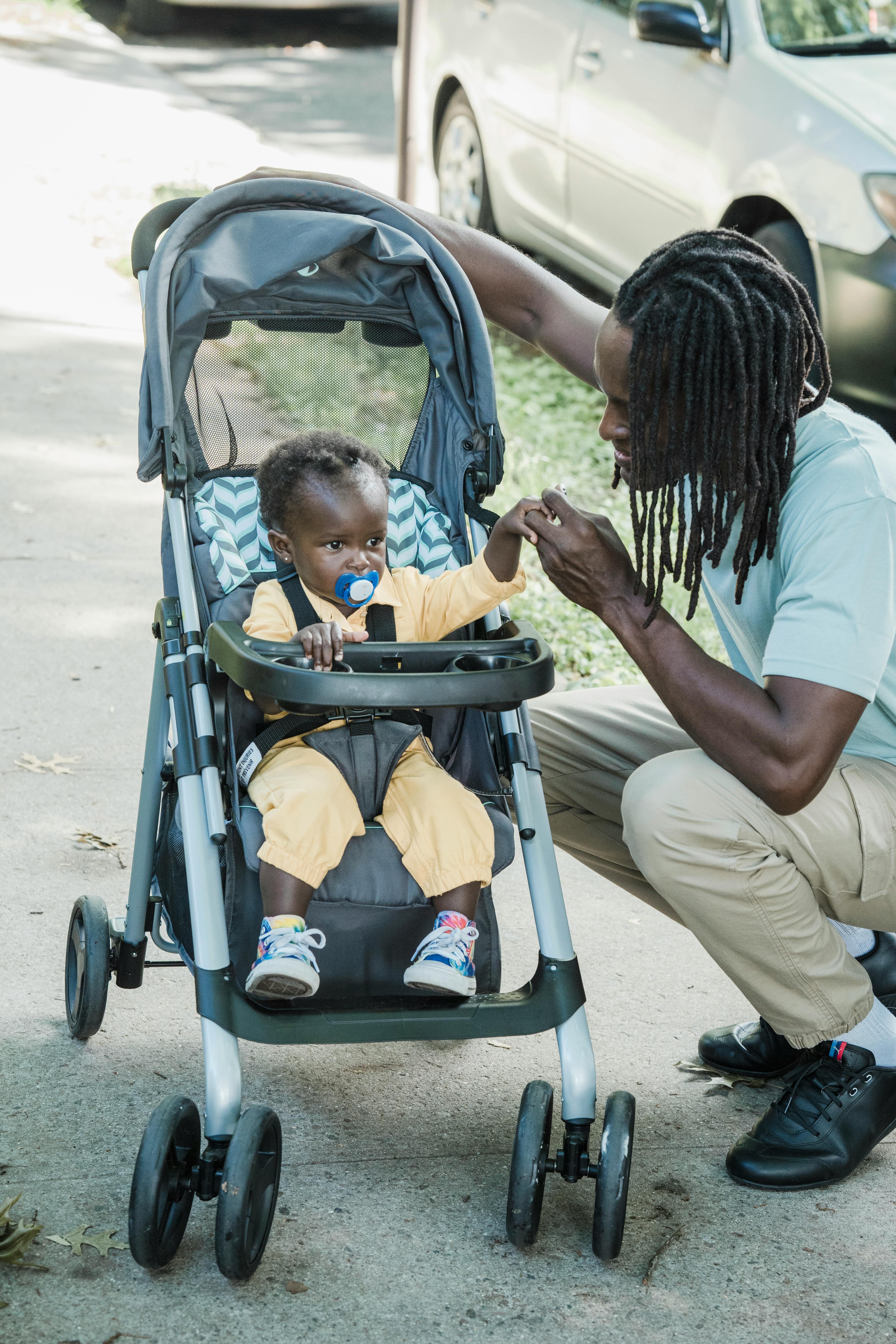 Father and baby sharing a moment of bonding outdoors in a stroller.