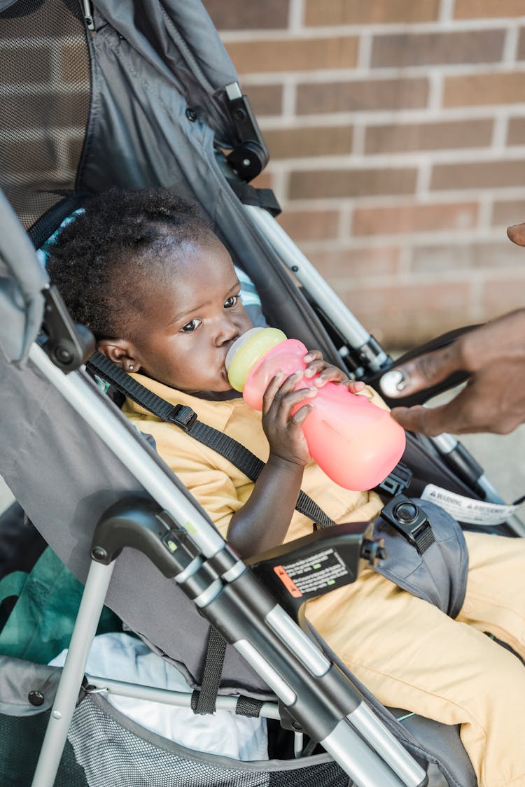 Baby Girl Drinking Milk On A Feeding Bottle