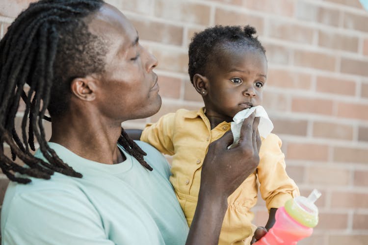 Man Wiping A Child's Face