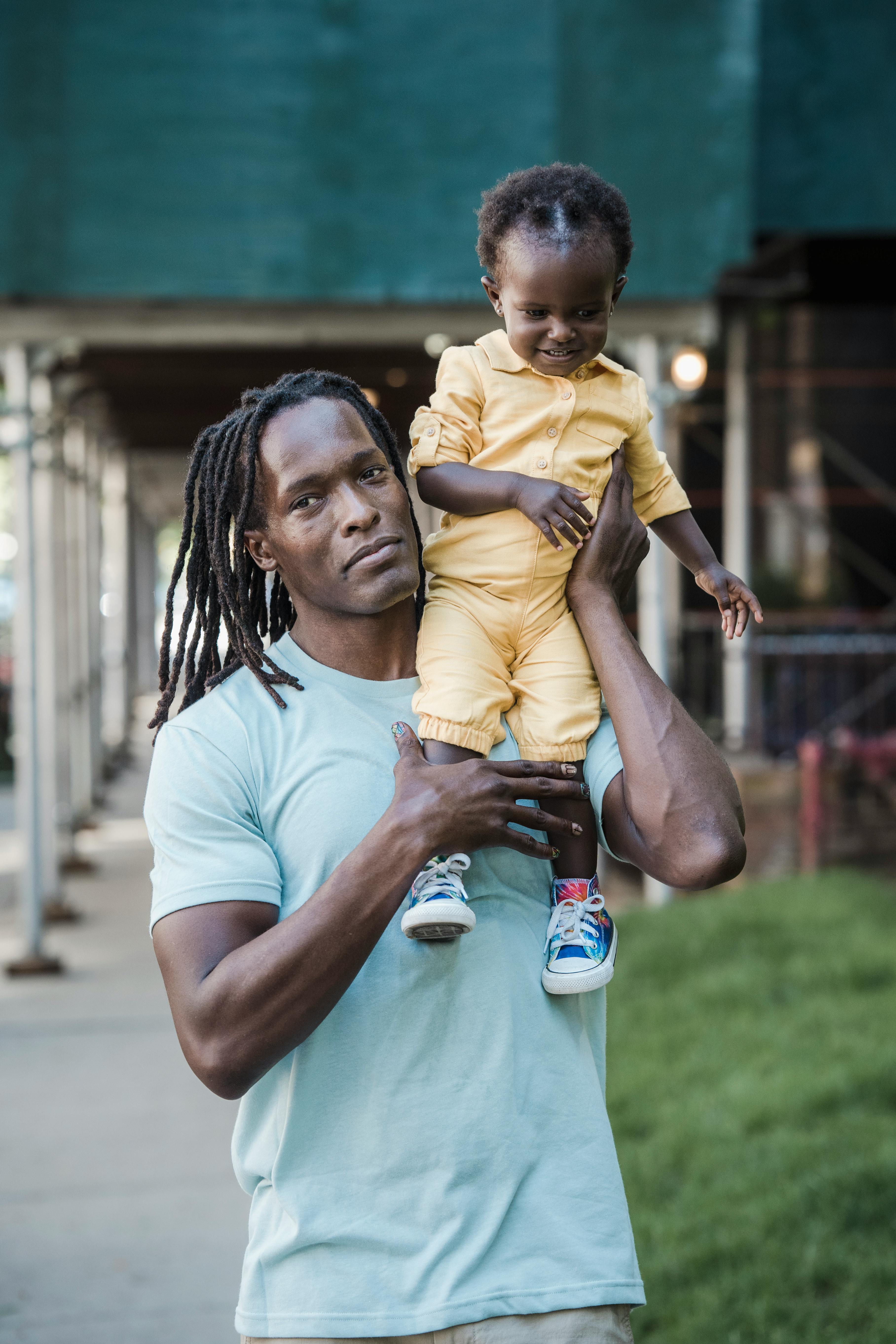 a man carrying a child on his shoulder