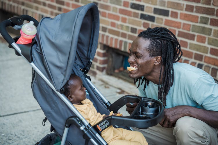 Man Taking Care Of Child In Pram