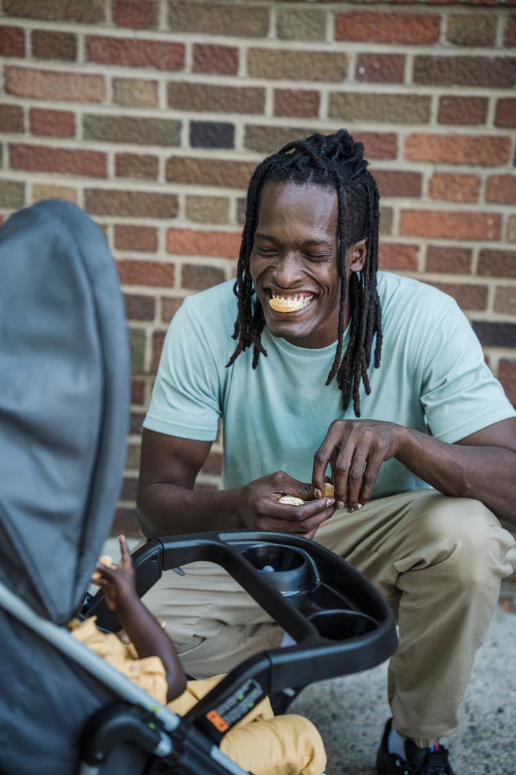 Smiling Man Crouching At Pram