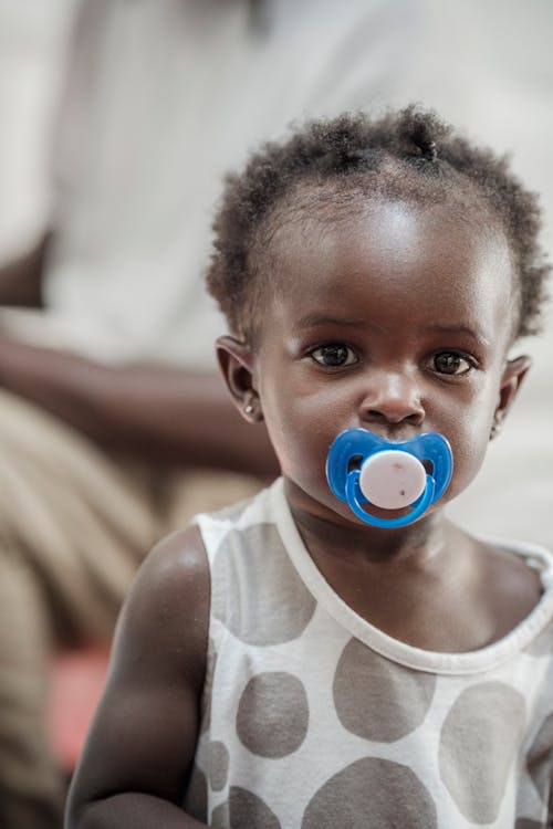Close Up Photo of a Little Girl with a Pacifier