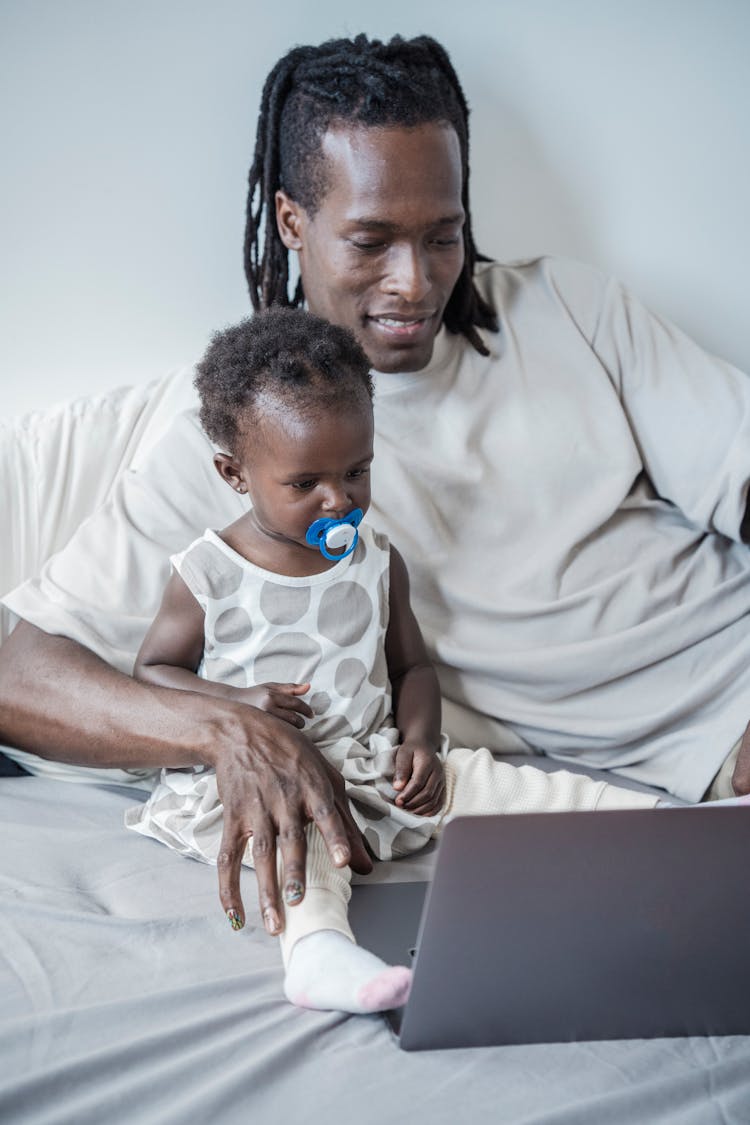 Father And Daughter Watching Something On Laptop 