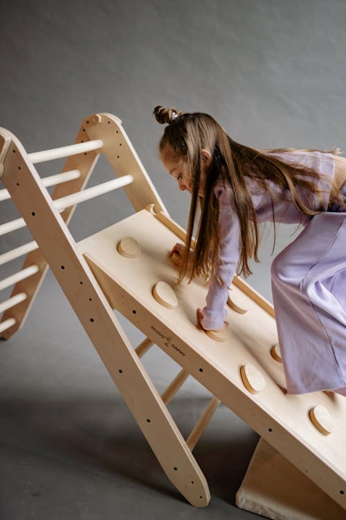 Girl Climbing Up the Wooden Ladder 