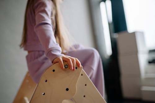 Close-up of Child Sitting on Wooden Ladder