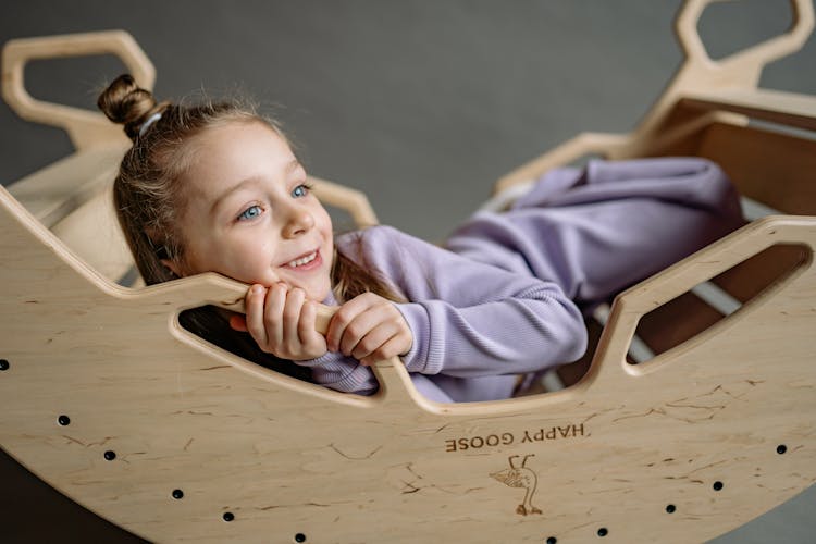 Cute Little Girl In A Wooden Rocking Boat