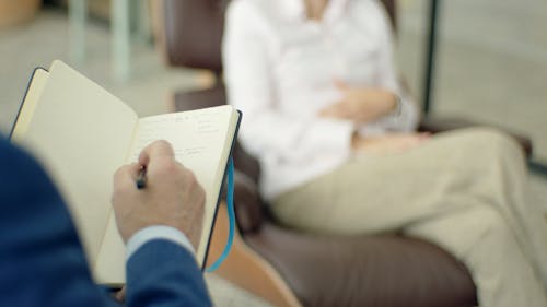 Person Writing on Notebook