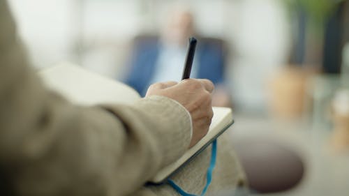 
Person Writing on Notebook