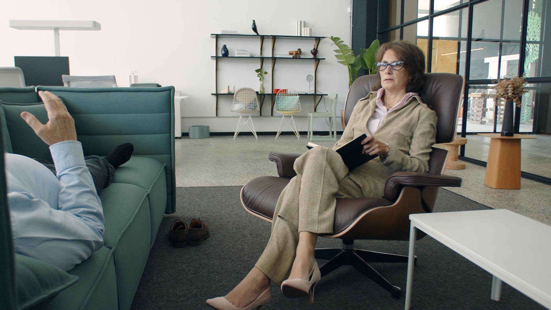 A psychiatrist and patient during a session in a modern office. Calm and professional atmosphere.