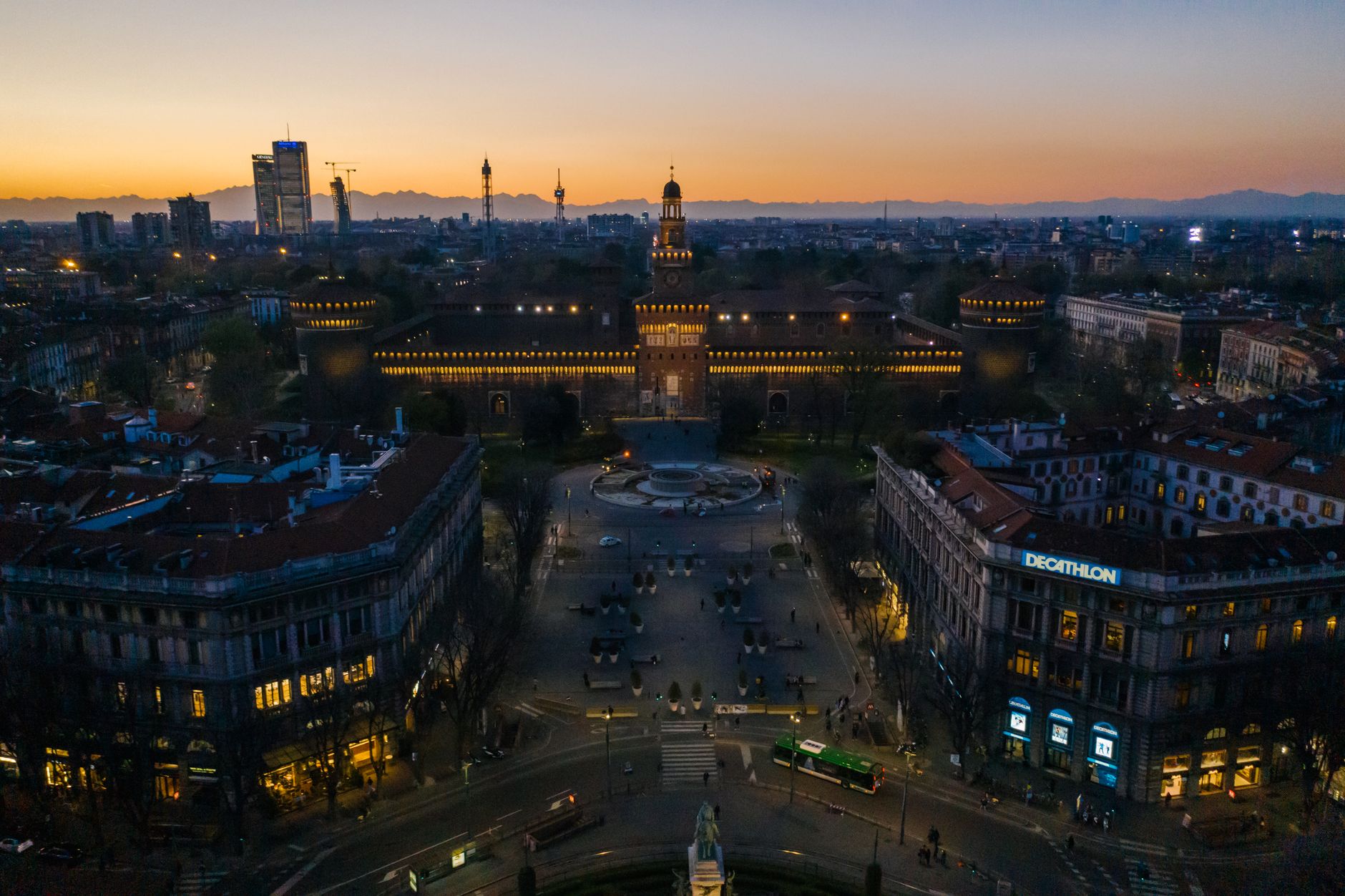 Captivating aerial view of Milan's Sforza Castle beautifully illuminated at dusk.