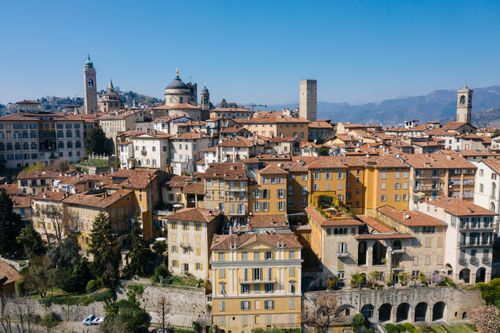 Free A scenic aerial view of Bergamo, Italy featuring historic buildings and landmarks under a clear blue sky. Stock Photo