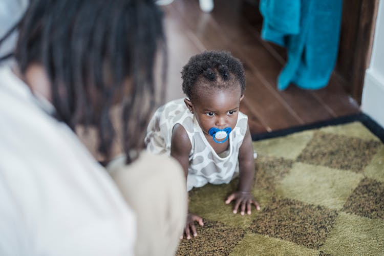 A Baby Crawling On A Wooden Floor