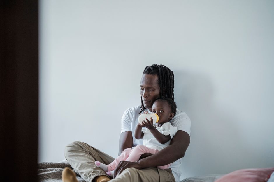 Dr. Brown’s vs Comotomo: Anti-Colic Bottle Feature Showdown A father cherishes a quiet moment, holding his baby indoors.