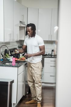 Adult man cooking fresh food in a contemporary kitchen setting, highlighting home cooking and lifestyle.