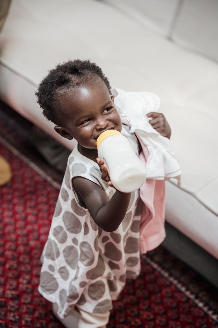 Cute Kid Drinking Milk From A Baby Bottle