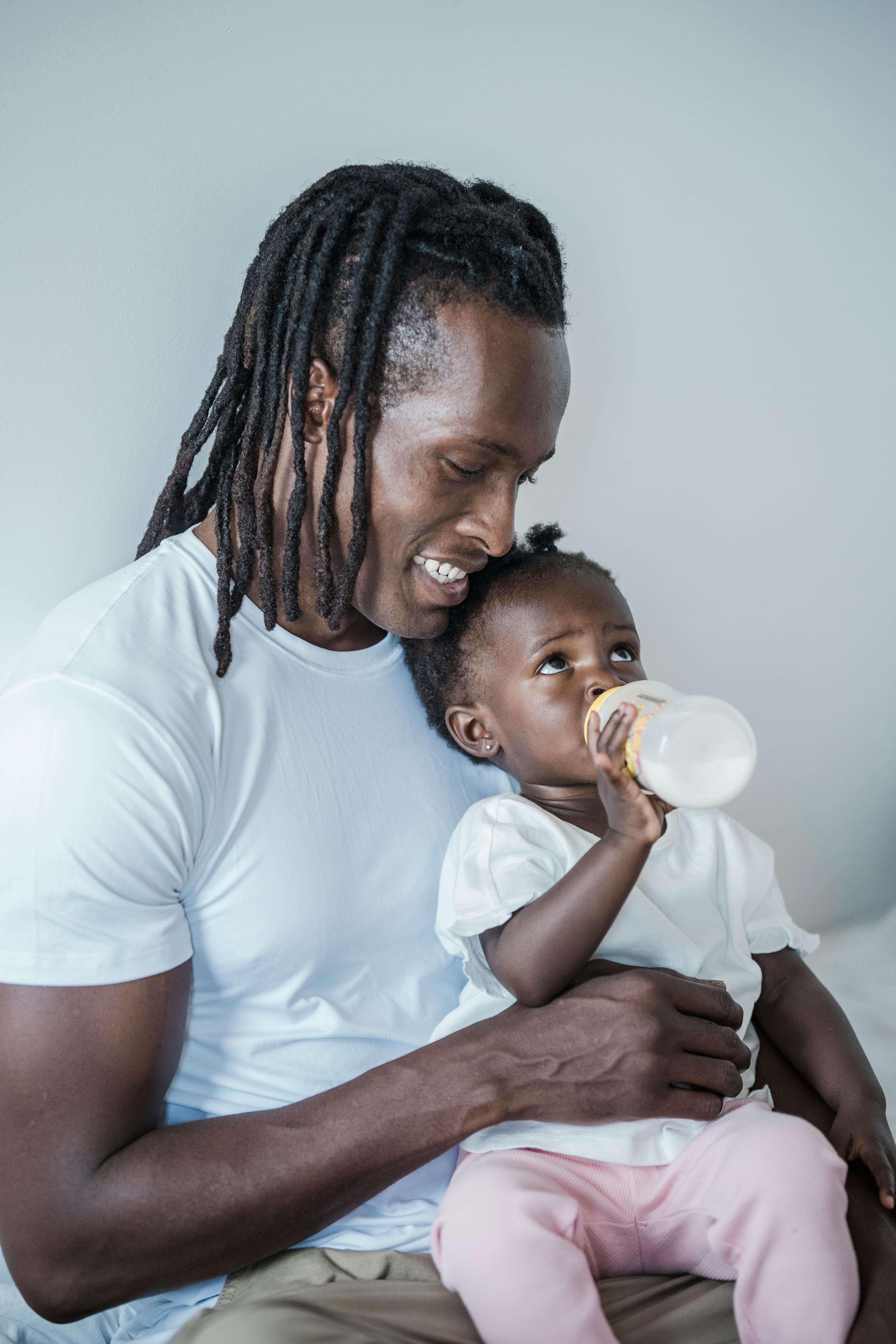 man in white crew neck shirt holding a baby