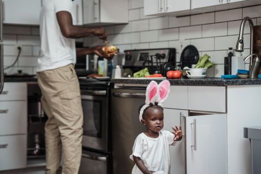 Man Preparing Food in the Kitchen and His Baby Daughter Running Around 