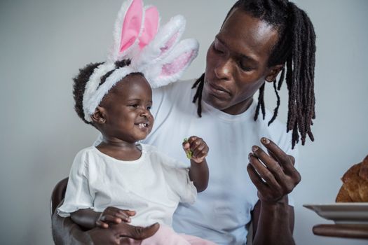 Portrait of Man Feeding his Baby Daughter with Rabbit Ears 